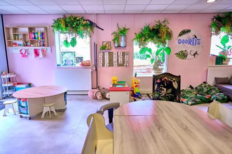 Roze groepsruimte met planten en tafel